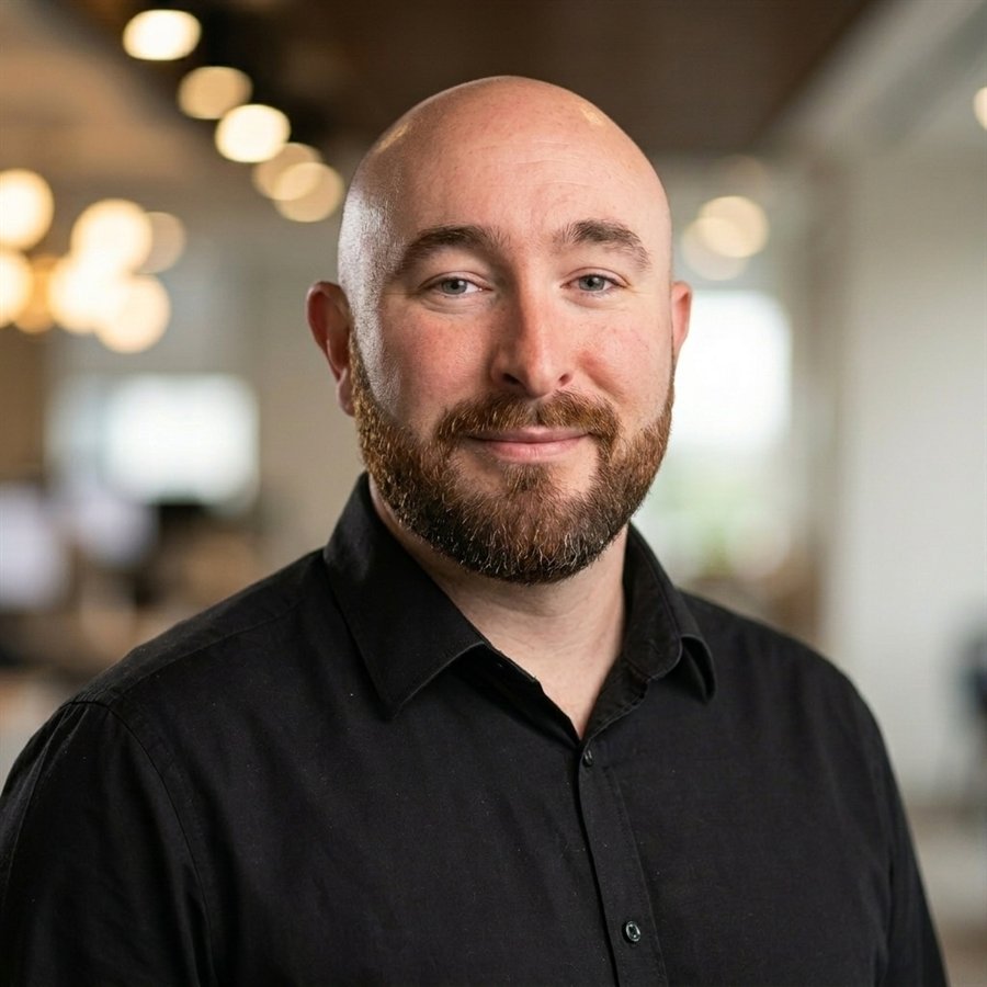 Mike, founder of BookedLocal, smiling in an office.